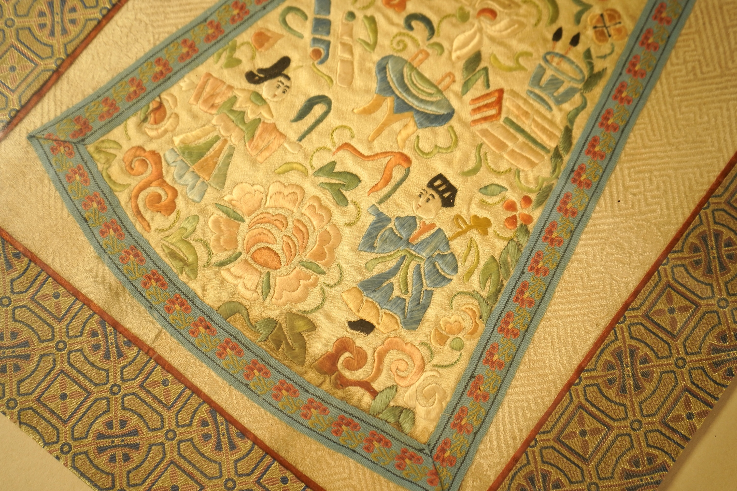 Two Chinese silk panels with polychrome embroidery, one housed in a faux bamboo frame, largest 47cm high